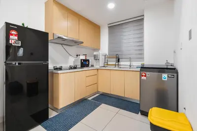 a kitchen with a black refrigerator and wooden cabinets at Sentul Homestay 3 Bedroom in Kuala Lumpur