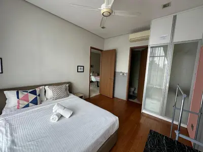 a bedroom with a bed with white sheets and a ceiling at Soho Suites KLCC 20 jalan perak in Kuala Lumpur