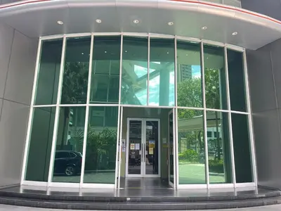 a large glass building with a revolving door at Vortex Suites KLCC by ZARA in Kuala Lumpur