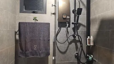 a bathroom with a shower with a towel at Neu Suites in Kuala Lumpur