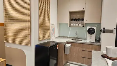 a kitchen with a black refrigerator and a sink at Neu Suites in Kuala Lumpur