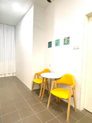a dining room with yellow chairs and a table at Cozy home in city center with free parking - 1A in Kuala Lumpur