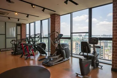 a gym with treadmills and ellipticals in a room with windows at Ceylonz Suites By Staybliss in Kuala Lumpur