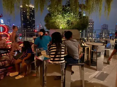 a group of people sitting at tables on a rooftop at Ceylonz Suites By Staybliss in Kuala Lumpur