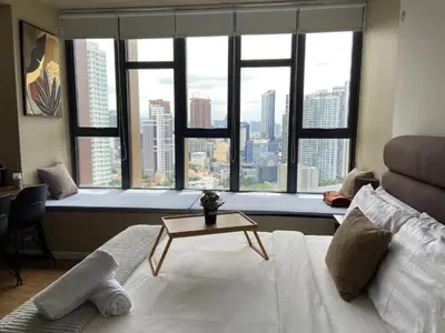 a bedroom with a bed and a window with a view at Ceylonz Suites By Staybliss in Kuala Lumpur
