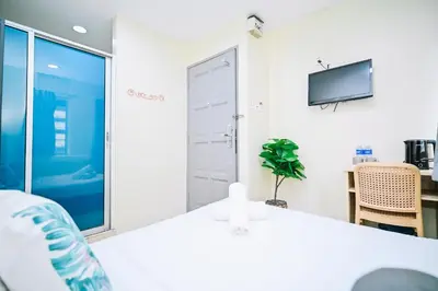 a white room with a sliding door and a tv at Swing & Pillows - My Home Hotel Wangsa Maju in Kuala Lumpur