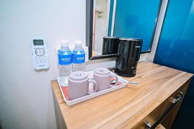 a wooden counter with cups and water bottles on it at Swing & Pillows - My Home Hotel Wangsa Maju in Kuala Lumpur