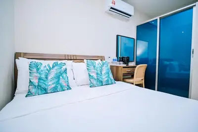 a bedroom with a large bed and a desk at Swing & Pillows - My Home Hotel Wangsa Maju in Kuala Lumpur