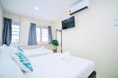 two white beds in a room with blue curtains at Swing & Pillows - My Home Hotel Wangsa Maju in Kuala Lumpur