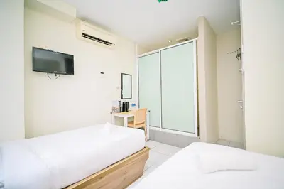 a bedroom with two beds and a tv on the wall at Swing & Pillows - My Home Hotel Wangsa Maju in Kuala Lumpur