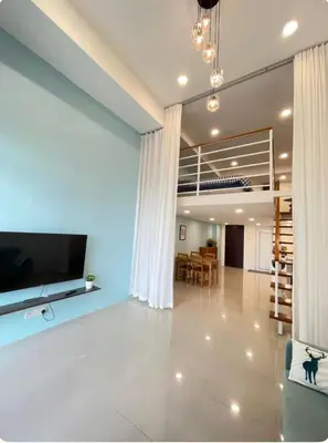 a living room with a large television and a dining room at Cozy home in city center with free parking -1C in Kuala Lumpur