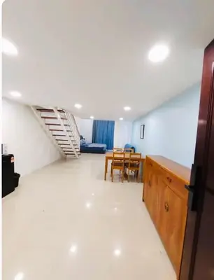 a large living room with a staircase and a table at Cozy home in city center with free parking -1C in Kuala Lumpur