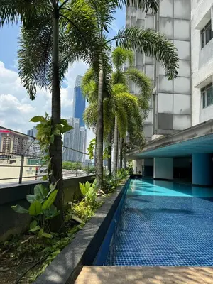 a swimming pool with palm trees and a building at Cozy home in city center with free parking -1C in Kuala Lumpur