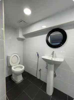 a bathroom with a toilet and a sink and a mirror at Cozy home in city center with free parking -1C in Kuala Lumpur