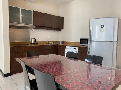 a kitchen with a table and a refrigerator at Couple Suite For Bukit Bintang S/R in Kuala Lumpur