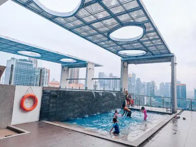 a group of children playing in a pool on the roof of a building at D'Majestic Place in Kuala Lumpur