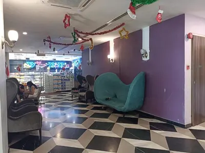 a waiting room with a green chair on a purple wall at D'Majestic Place, 1 King or 2 Super Single beds in Kuala Lumpur