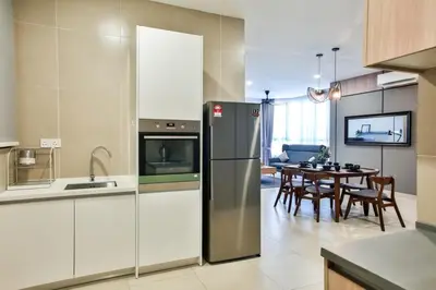 a kitchen with a refrigerator and a dining room at KL Gateway Residences in Kuala Lumpur