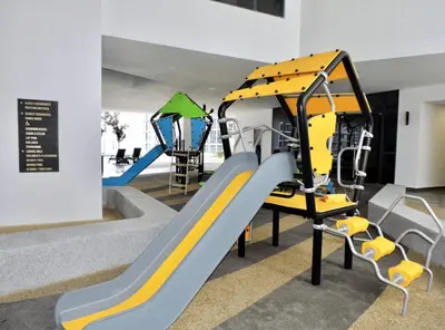 a playground with a slide and two swings at KL Gateway Residences in Kuala Lumpur