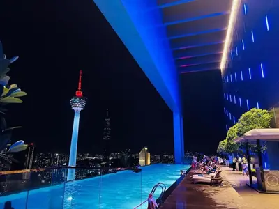 a pool with a view of the space needle at night at The Platinum Kuala Lumpur KLCC By Garden Suites in Kuala Lumpur