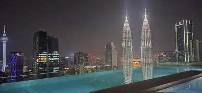 a view of a city skyline at night with a swimming pool at Imperial Suites KLCC in Kuala Lumpur