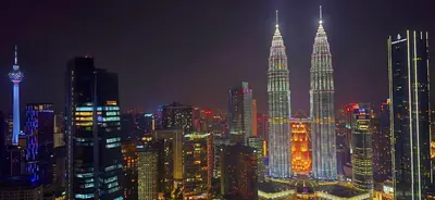 a city skyline at night with the petronas towers at Imperial Suites KLCC in Kuala Lumpur