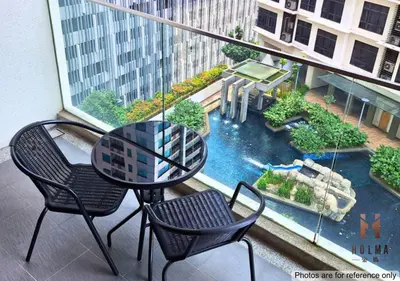 a table and chairs on a balcony with a view of a river at 188 Suites KLCC by Holma in Kuala Lumpur