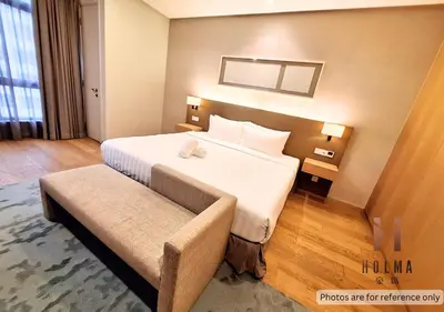 a hotel room with a large bed and a bench at 188 Suites KLCC by Holma in Kuala Lumpur