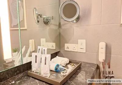 a bathroom with a mirror and a counter with towels at 188 Suites KLCC by Holma in Kuala Lumpur