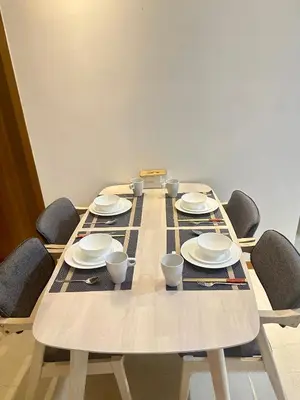 a long wooden table with chairs and plates on it at 2bedroom SOHO SUITE KLCC View by Homeizing in Kuala Lumpur