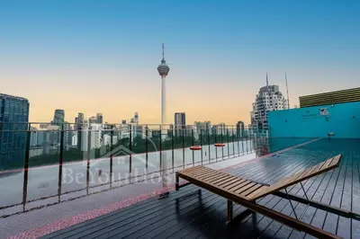 a wooden bench on a balcony with a view of a city at Suites at Maison 101,Heart Of KL City in Kuala Lumpur