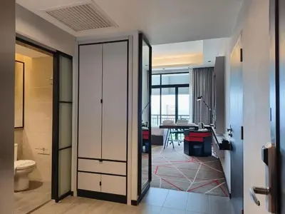 a bathroom with a toilet and a room with a table at Suites at Maison 101,Heart Of KL City in Kuala Lumpur