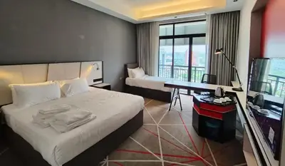 a hotel room with a bed and a desk and a television at Suites at Maison 101,Heart Of KL City in Kuala Lumpur