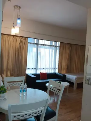 a living room with a couch and a table and chairs at KL Apartment At Berjaya Times Square in Kuala Lumpur