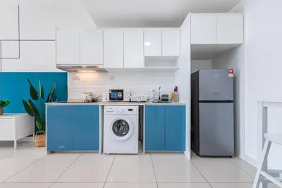 a kitchen with a washing machine and a refrigerator at Exquisite KL Retreat Pool & Gym High Speed 100MB in Kuala Lumpur