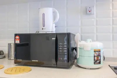 a microwave sitting on a kitchen counter next to a mixer at Continew TRX Corner House +2 Balconies +2 Rooms in Kuala Lumpur