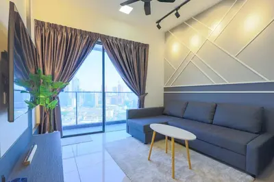 a living room with a blue couch and a table at Continew TRX Corner House +2 Balconies +2 Rooms in Kuala Lumpur