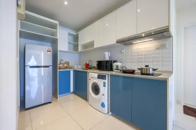 a kitchen with blue cabinets and a washing machine at Continew TRX Corner House +2 Balconies +2 Rooms in Kuala Lumpur