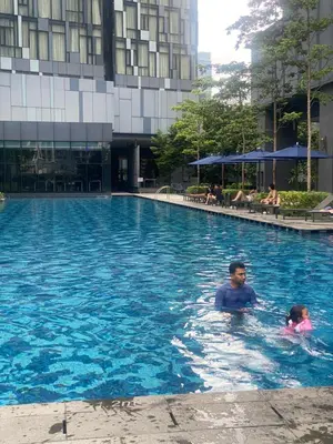 a man and a child swimming in a swimming pool at Eastern Suites Star KLcc in Kuala Lumpur