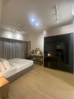 a bedroom with a large white bed and a table at Eastern Suites Star KLcc in Kuala Lumpur