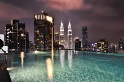 a rooftop pool with a city skyline at night at The Dorsett Residence Service Suite Bukit Bintang KL in Kuala Lumpur