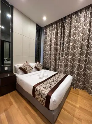 a bedroom with a large bed and a curtain at The Dorsett Residence Service Suite Bukit Bintang KL in Kuala Lumpur