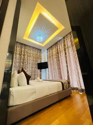 a bedroom with a large bed in front of curtains at The Dorsett Residence Service Suite Bukit Bintang KL in Kuala Lumpur