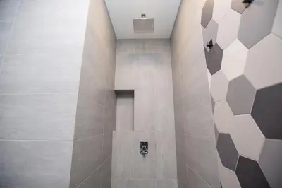 a bathroom with a shower with a tile floor at Ceylonz Suites near KLCC& KL Tower by My Trip & My Stay in Kuala Lumpur