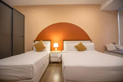 two beds in a room with an arch above them at Ceylonz Suites near KLCC& KL Tower by My Trip & My Stay in Kuala Lumpur