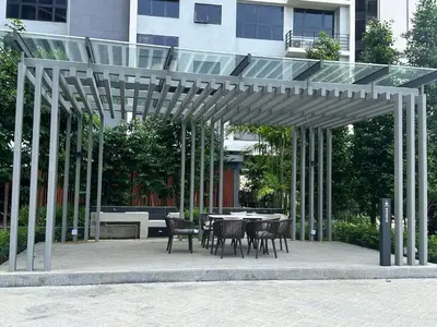 a wooden pergola with a table and chairs in front of a building at Agile Bukit Bintang Suites TRX in Kuala Lumpur
