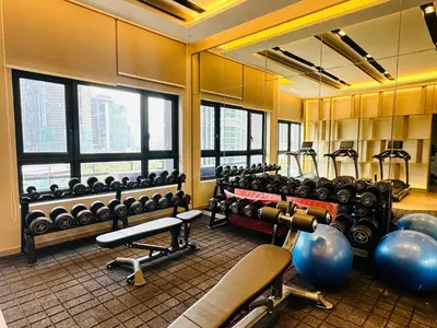 a gym with lots of exercise equipment and windows at Agile Bukit Bintang Suites TRX in Kuala Lumpur