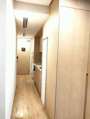 a kitchen with wooden cabinets and a hallway at 188 Suites KLCC by Premium Suites in Kuala Lumpur