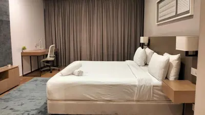 a hotel room with a large white bed and a desk at 188 Suites KLCC by Premium Suites in Kuala Lumpur