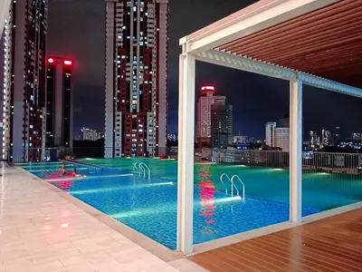 a swimming pool with a view of a city at night at Chambers Residence by Manhattan Group in Kuala Lumpur